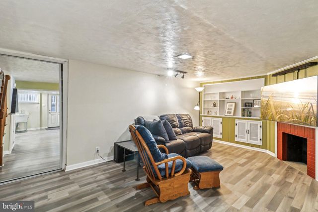 a view of a house with a small yard and large tree