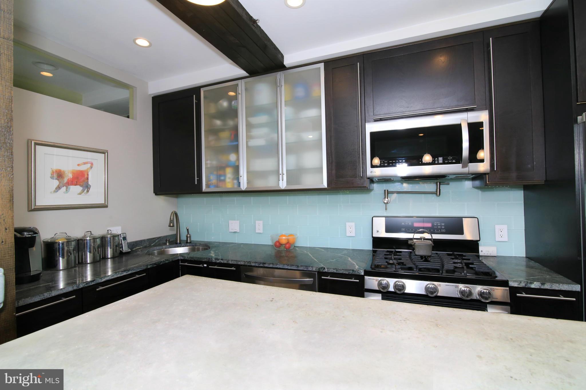 3603 Gunston Road, Unit 3603 Alexandria, VA 22302 - Photo 6 of 27 a kitchen with stainless steel appliances a stove a microwave a sink and cabinets
