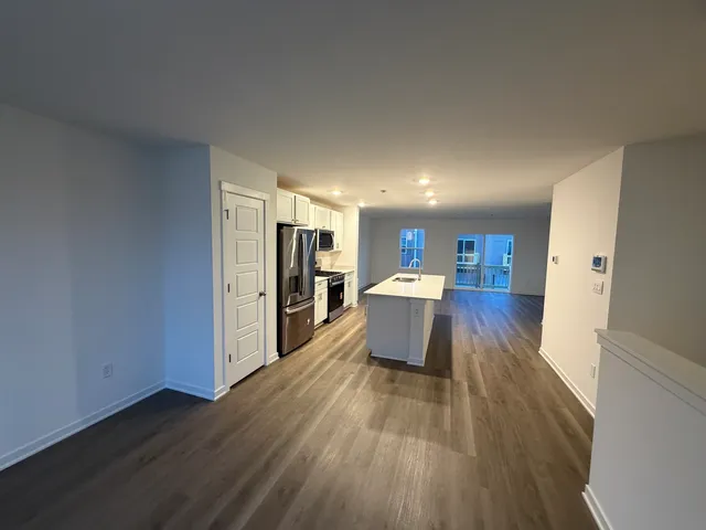 a large white kitchen with wooden floors and a fireplace