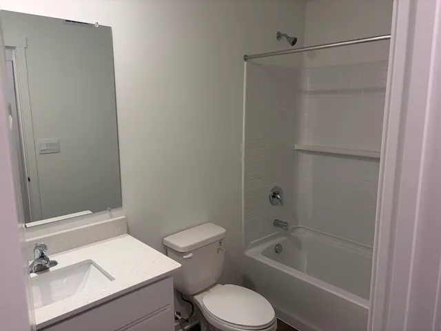 a bathroom with a granite countertop toilet a sink and bathtub
