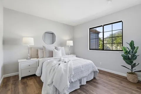 a bedroom with bed and wooden floor