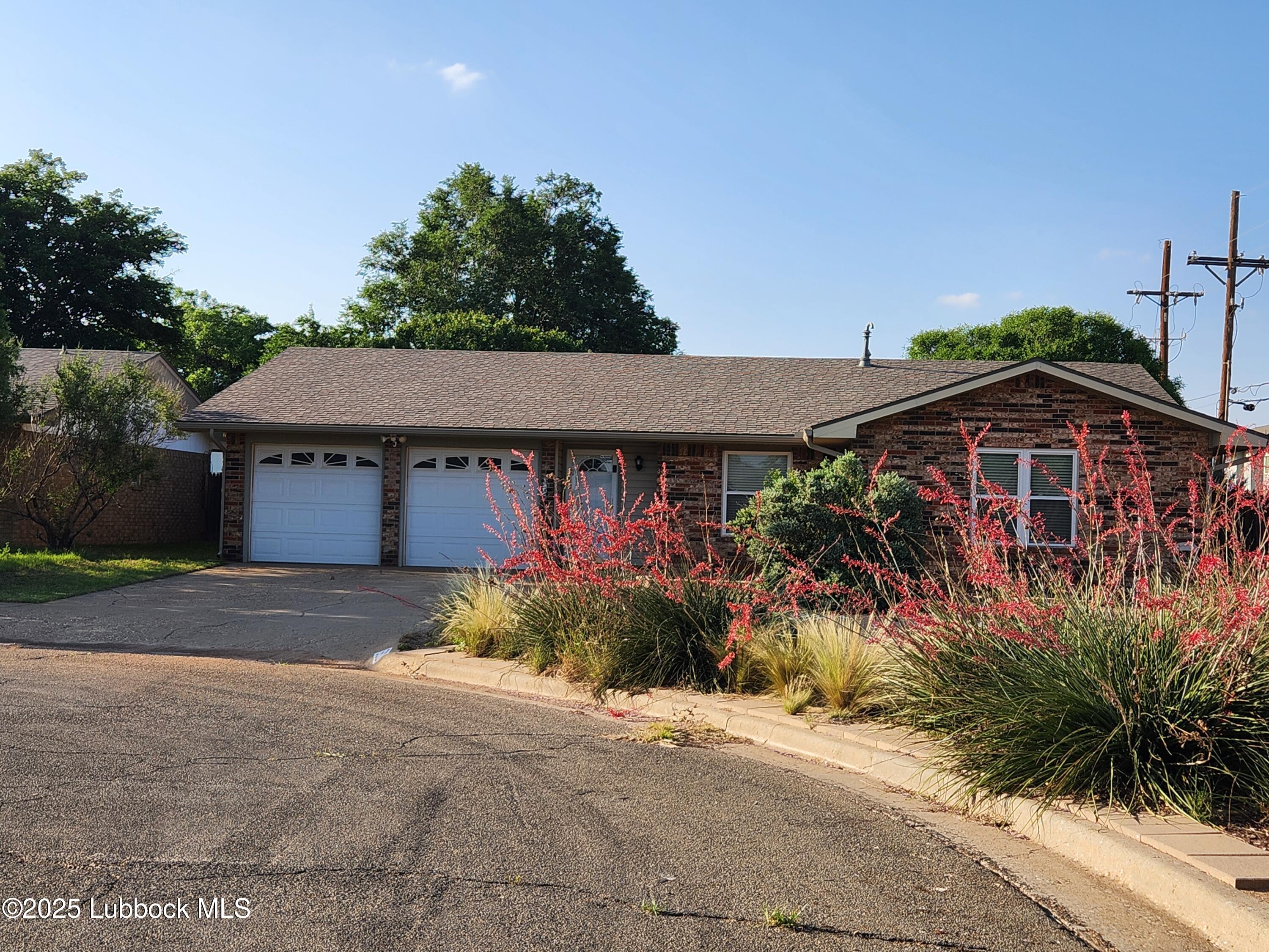 a front view of house with yard and trees around