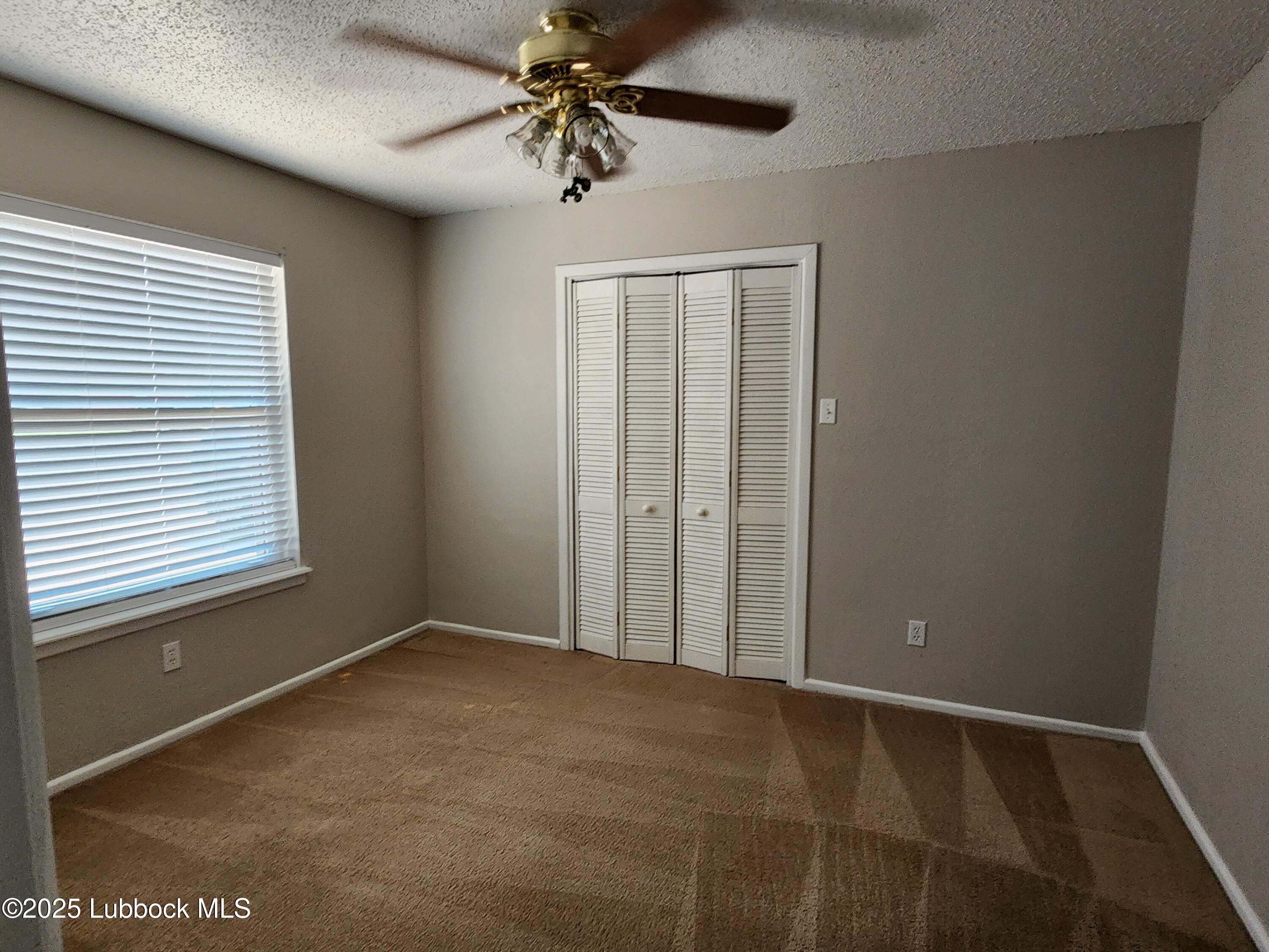 5502 Amherst Street Lubbock, TX 79416 - Photo 13 of 26 an empty room with windows and fan