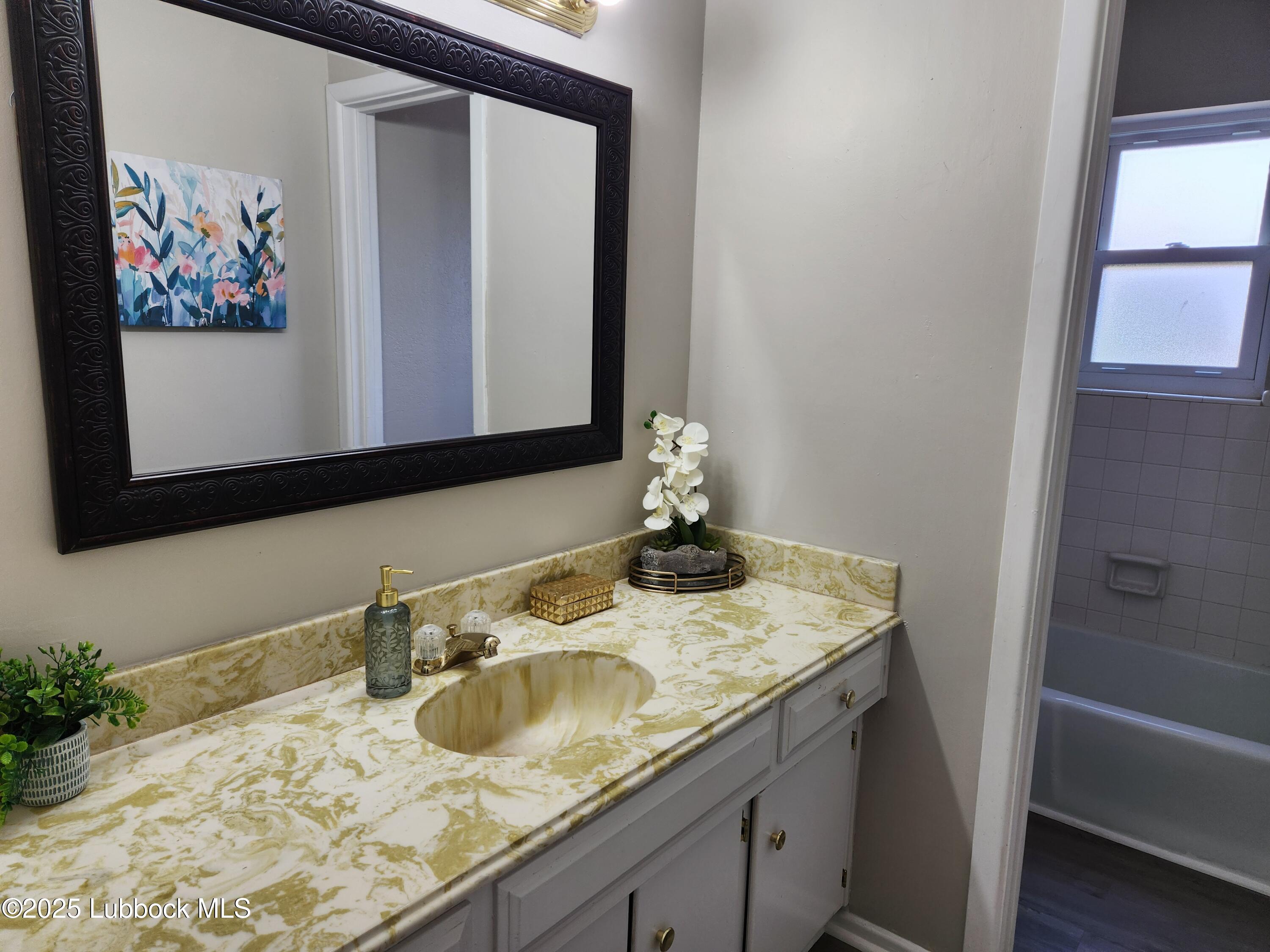 5502 Amherst Street Lubbock, TX 79416 - Photo 14 of 26 a bathroom with a granite countertop sink and a mirror