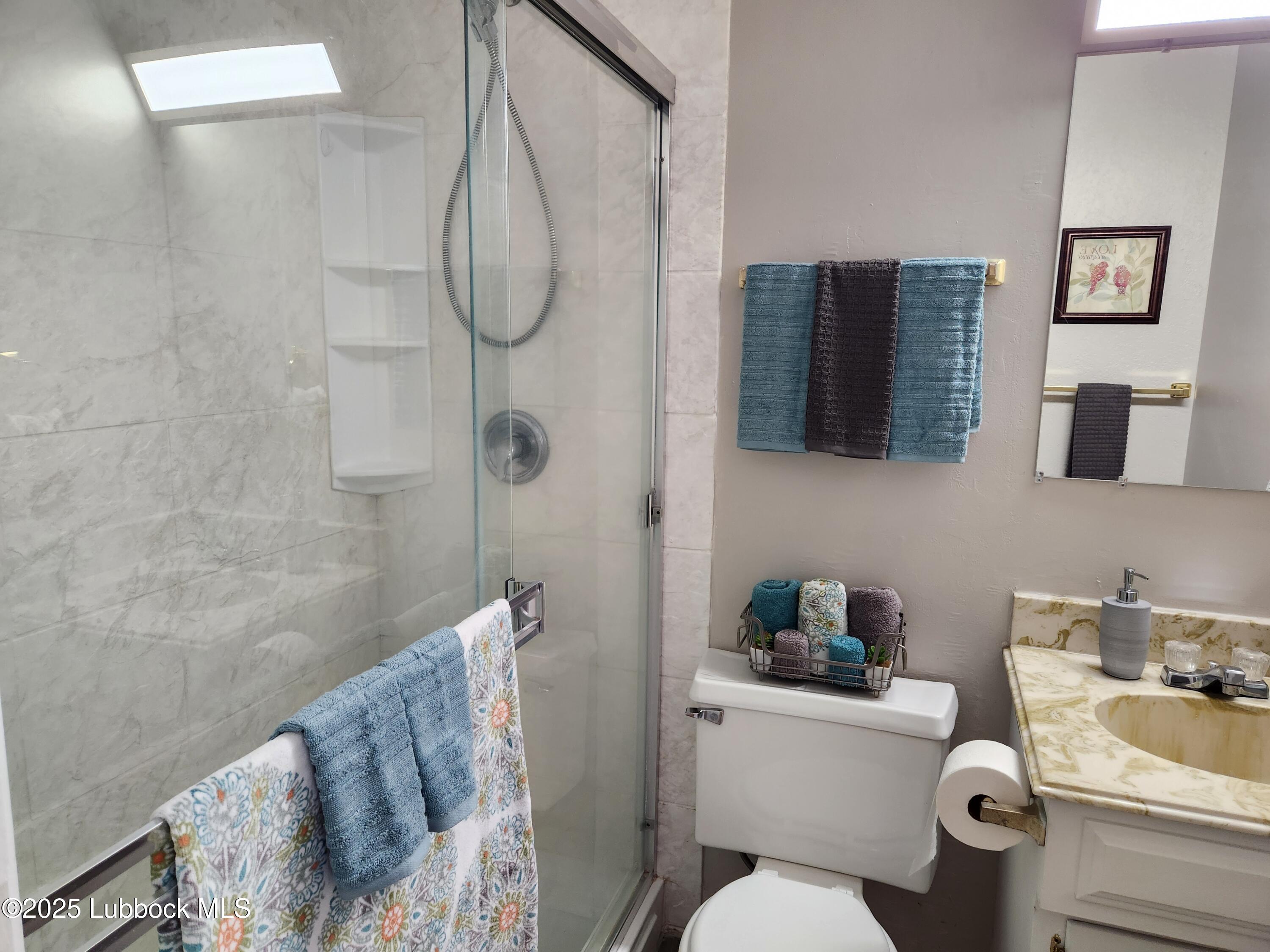 5502 Amherst Street Lubbock, TX 79416 - Photo 20 of 26 a bathroom with a toilet sink and shower