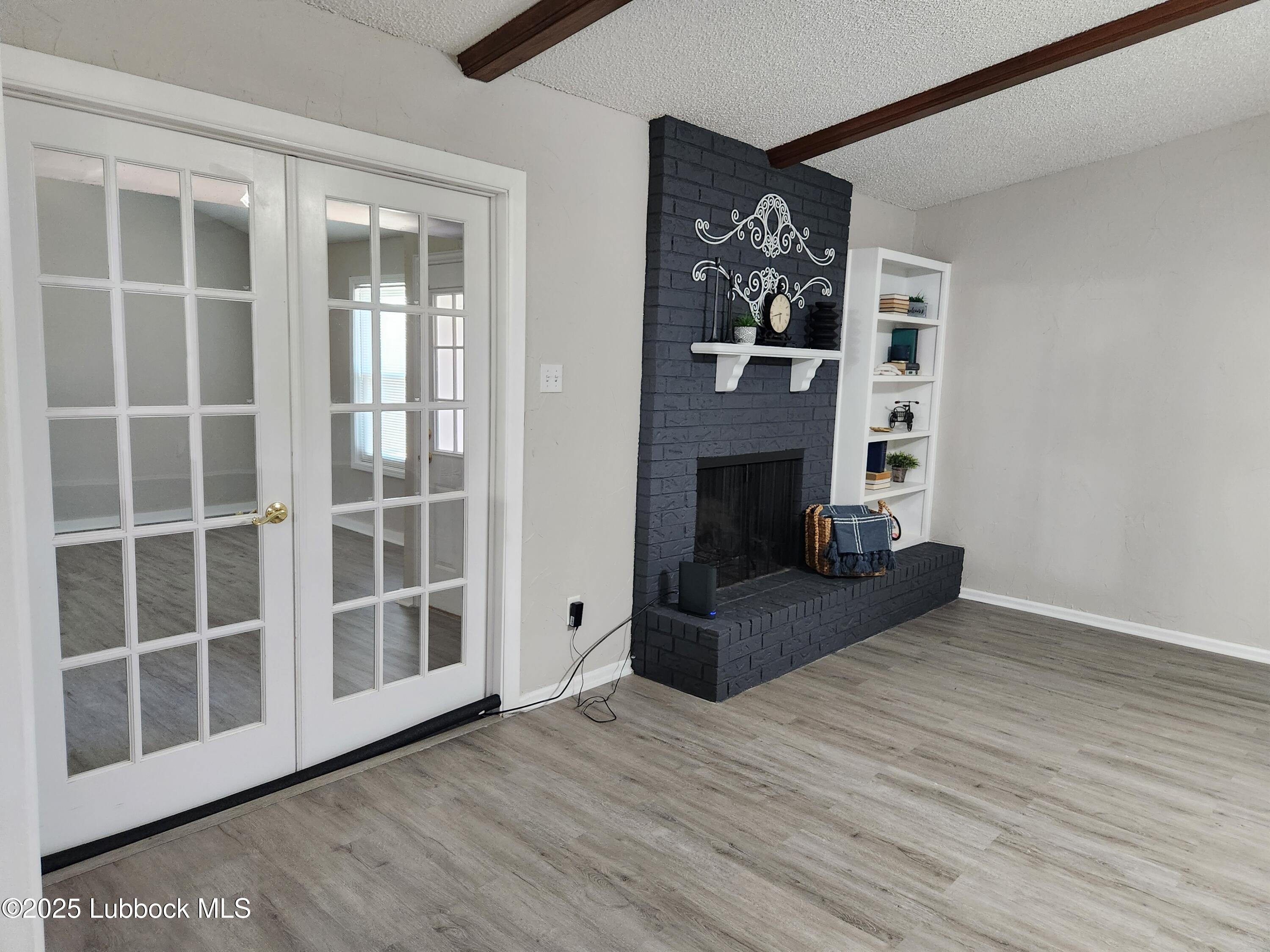 5502 Amherst Street Lubbock, TX 79416 - Photo 4 of 26 a view of an empty room with wooden floor and a window