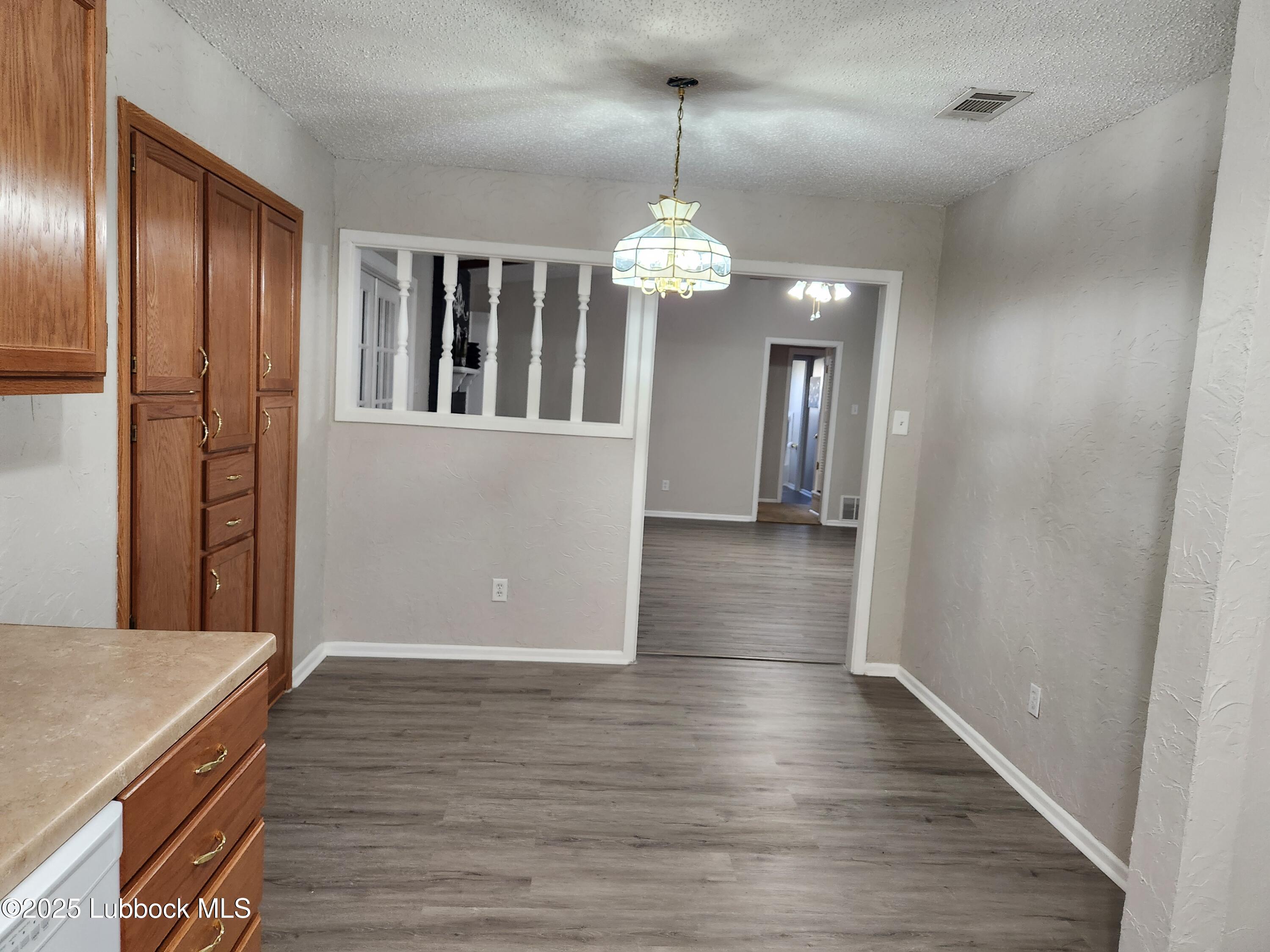 5502 Amherst Street Lubbock, TX 79416 - Photo 5 of 26 a view of a livingroom with a chandelier wooden floor and chandelier
