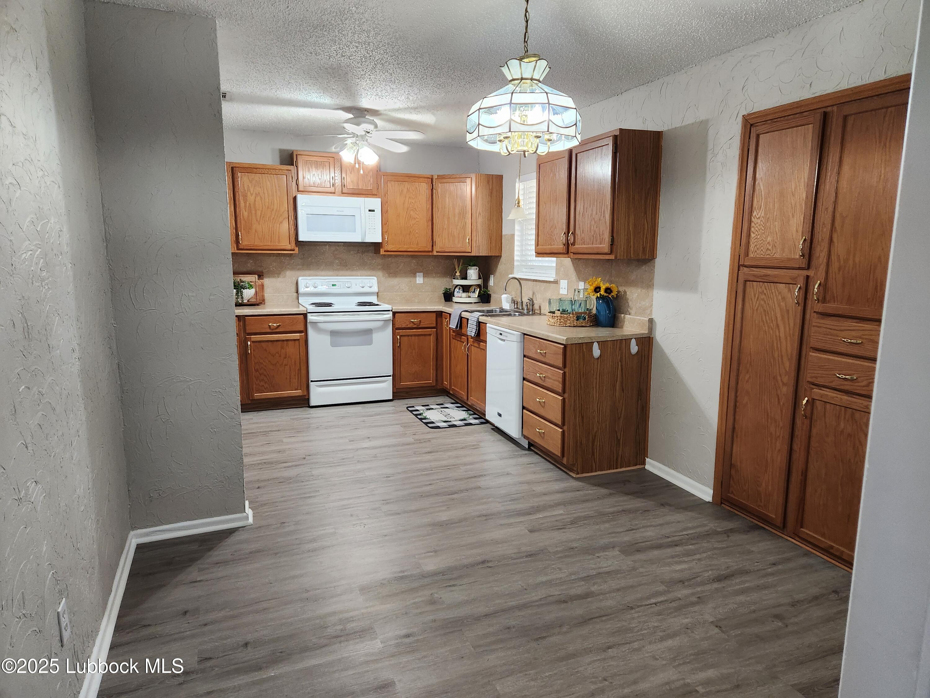 5502 Amherst Street Lubbock, TX 79416 - Photo 6 of 26 a large kitchen with a center island wooden floor stainless steel appliances and cabinets