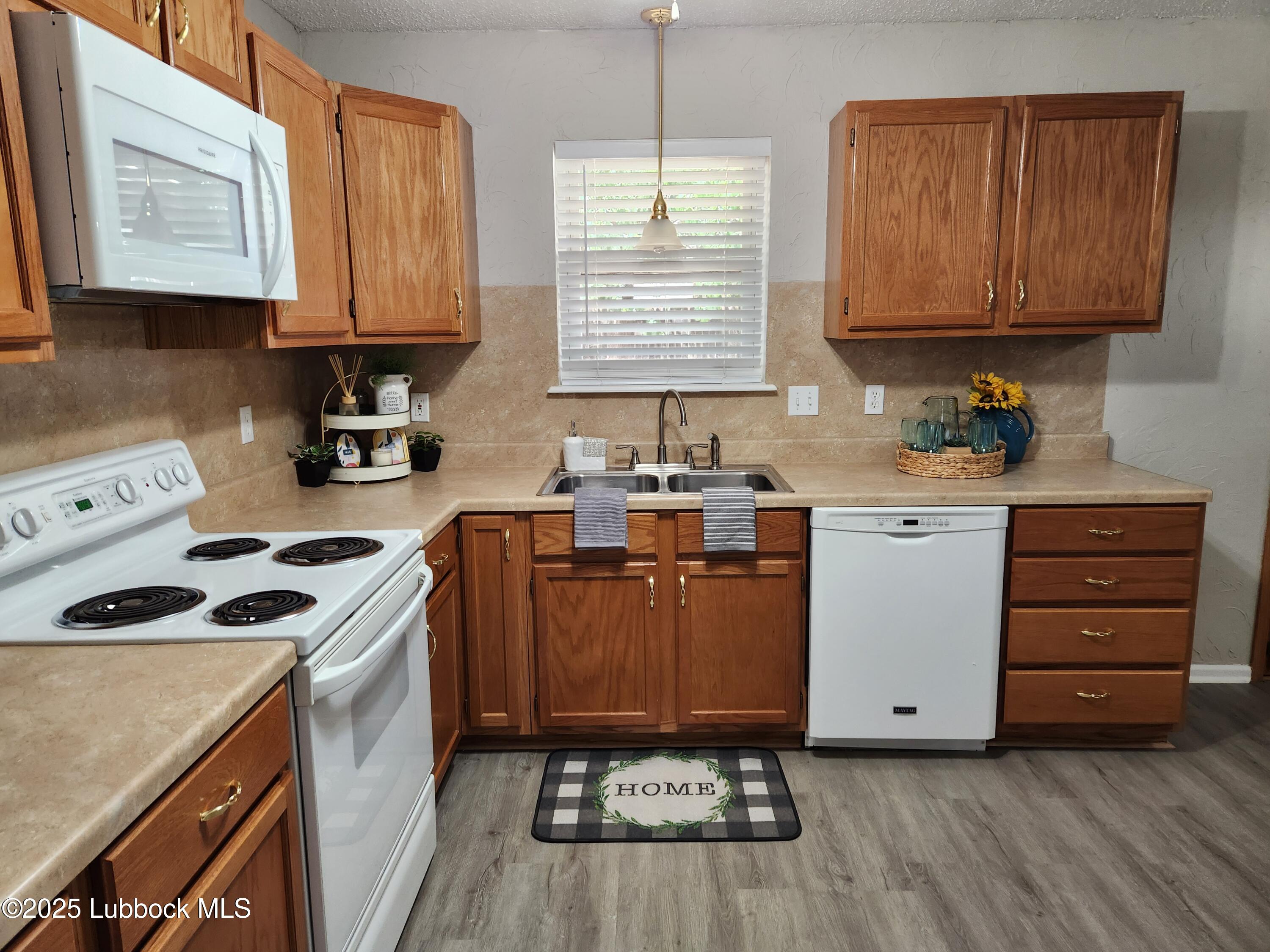 5502 Amherst Street Lubbock, TX 79416 - Photo 7 of 26 a kitchen with stainless steel appliances a stove a sink and a microwave