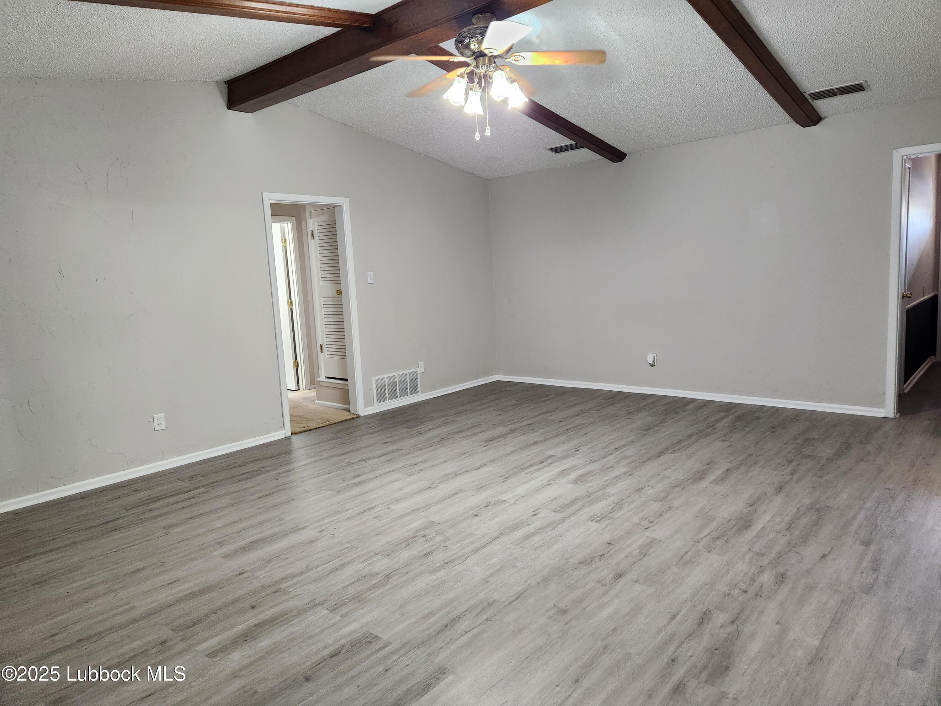 5502 Amherst Street Lubbock, TX 79416 - Photo 9 of 26 wooden floor in an empty room
