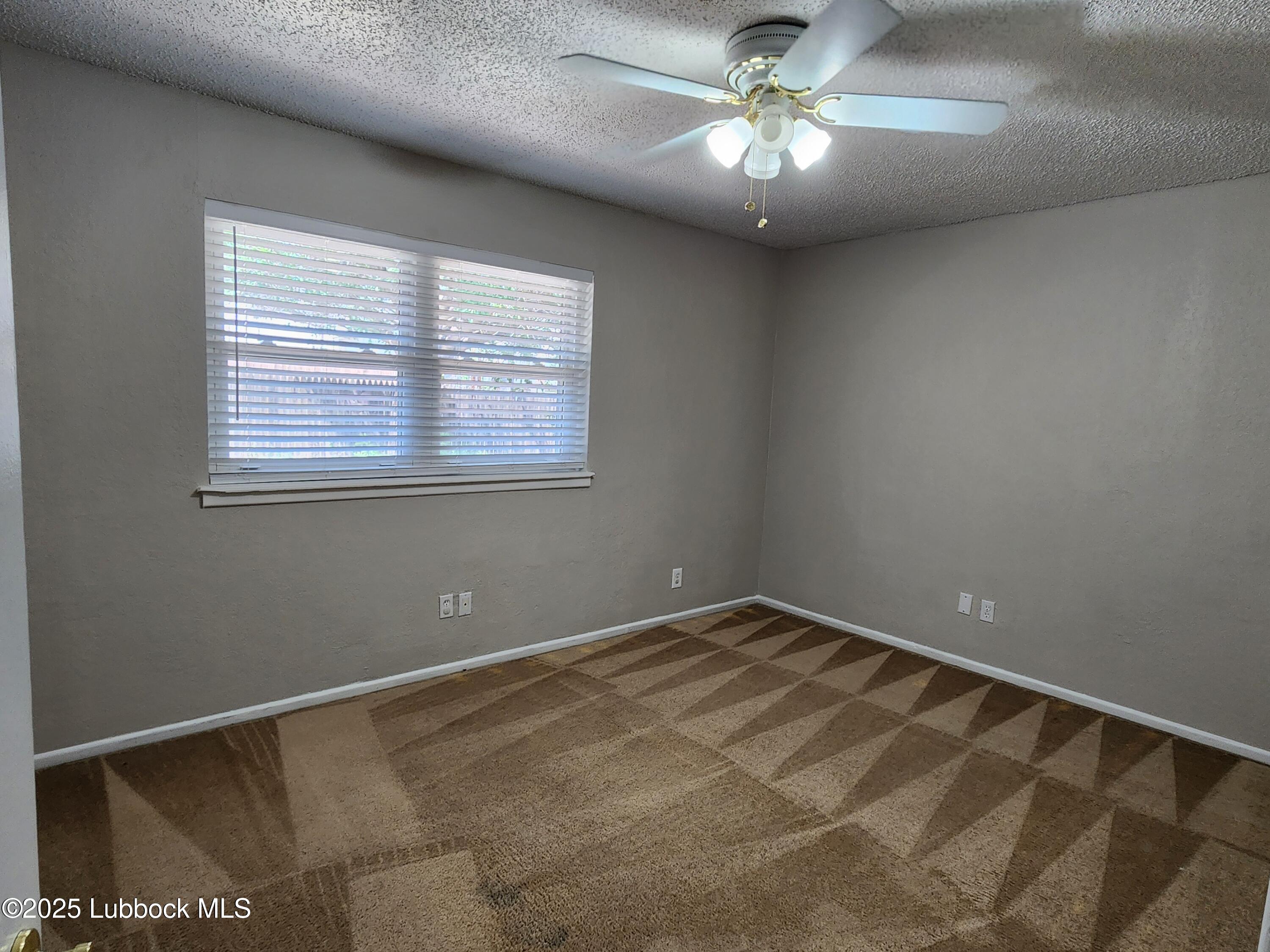 5502 Amherst Street Lubbock, TX 79416 - Photo 10 of 26 a view of a room with a ceiling fan and a window