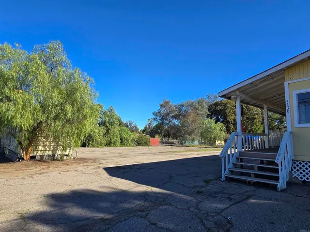a view of backyard with wooden fence and trees around