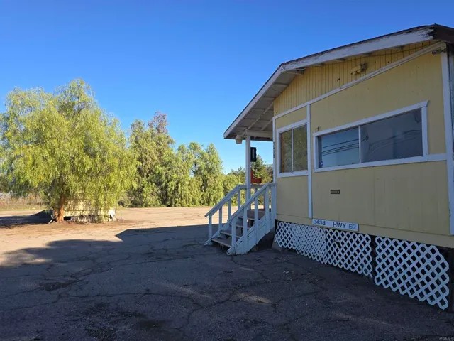 a view of a house with backyard and trees