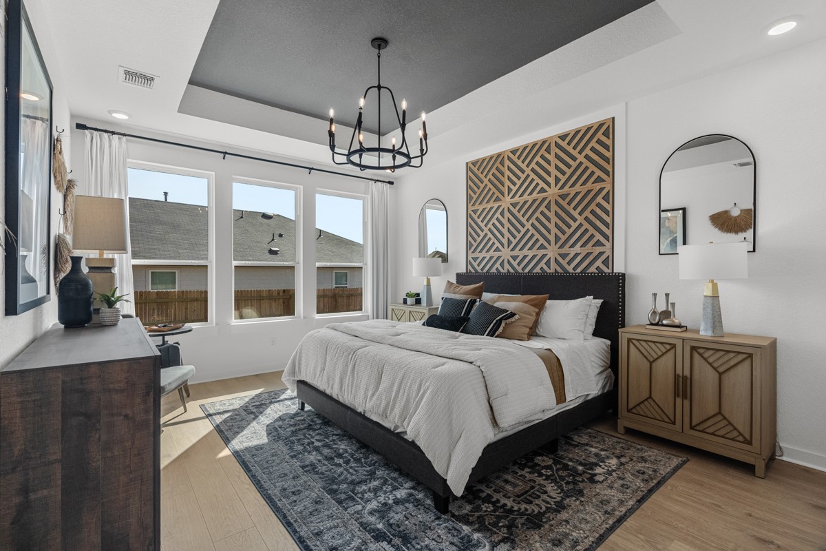 20400 Stelfox Street Manor, TX 78653 - Photo 18 of 37 Bedroom featuring recessed lighting, a raised ceiling, light wood finished floors, and a chandelier