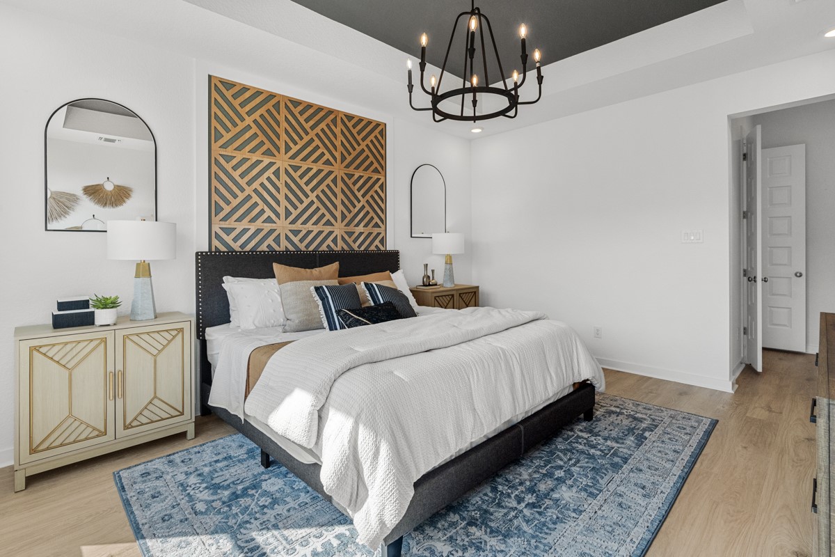 20400 Stelfox Street Manor, TX 78653 - Photo 20 of 37 Bedroom with light wood-type flooring, a chandelier, recessed lighting, and a raised ceiling