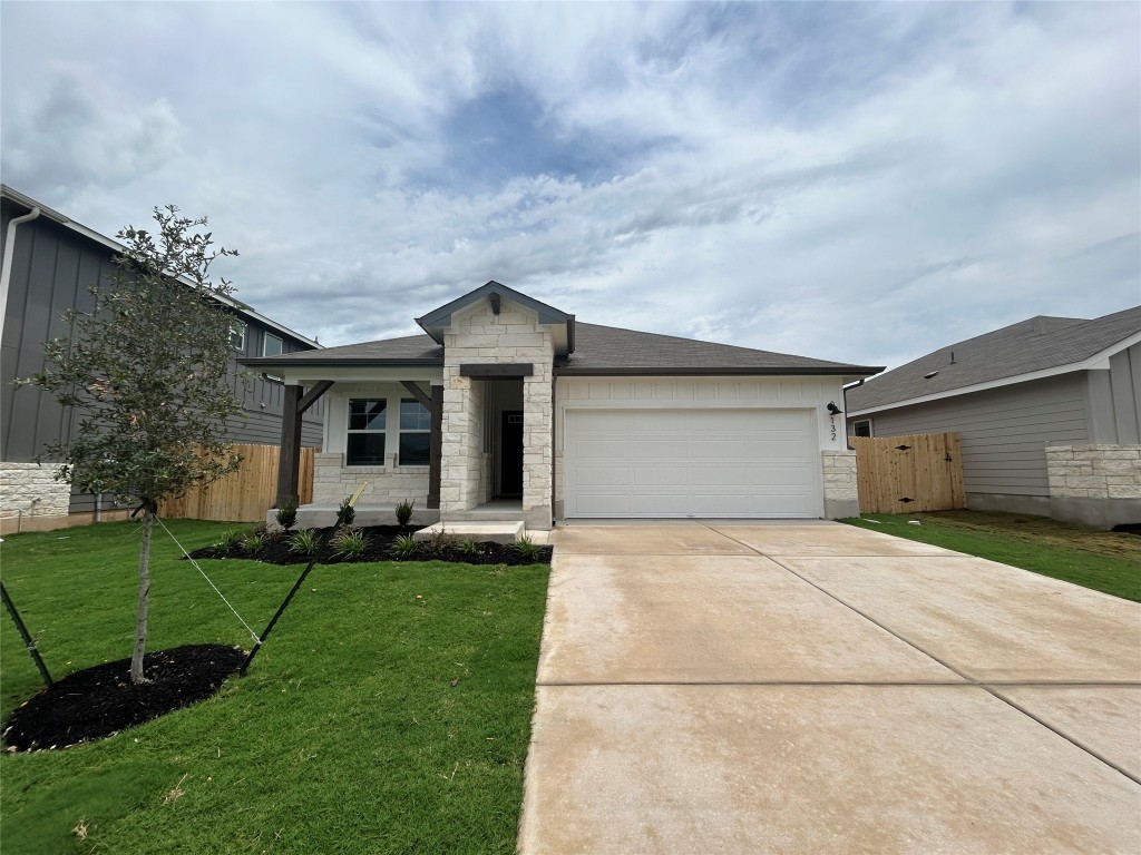 132 Honey Bee Road Jarrell, TX 76537 - Photo 1 of 1 View of front facade featuring stone siding, a garage, concrete driveway, and a shingled roof