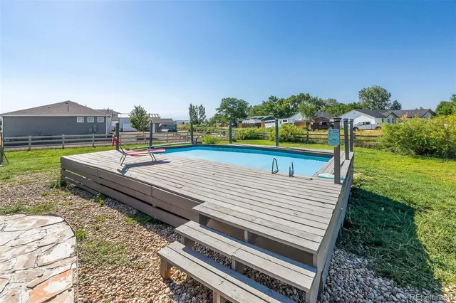 a view of a patio with swimming pool and a yard