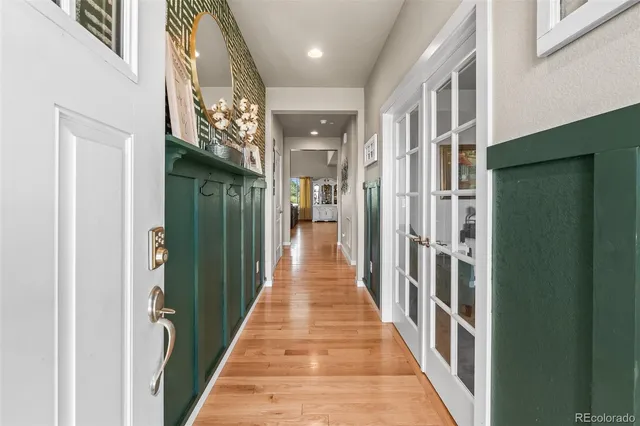 a view of a hallway with wooden floor and staircase
