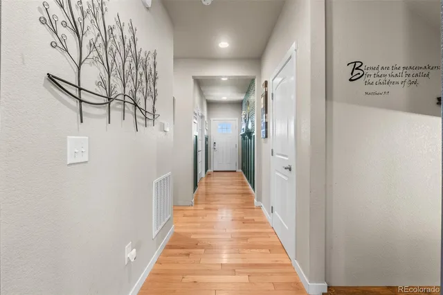 a view of a hallway with wooden floor and staircase
