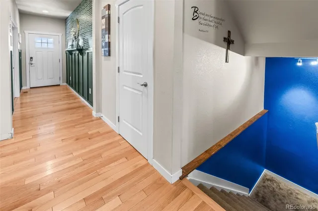 a view of a hallway with wooden floor and staircase