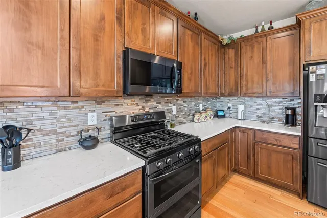 a kitchen with stainless steel appliances a stove a sink a microwave and cabinets