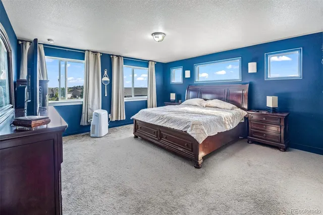 a bedroom with a bed and large windows