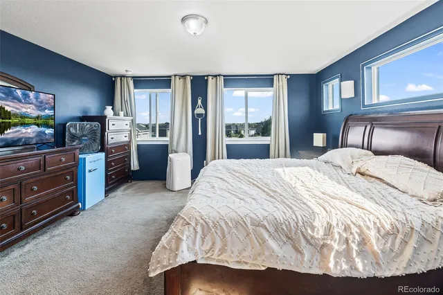 a bedroom with a bed and large windows