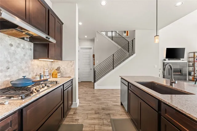 a kitchen with granite countertop a sink and a stove top oven
