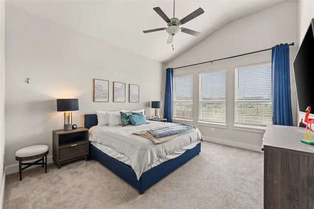 a spacious bedroom with a bed a couch and a large window