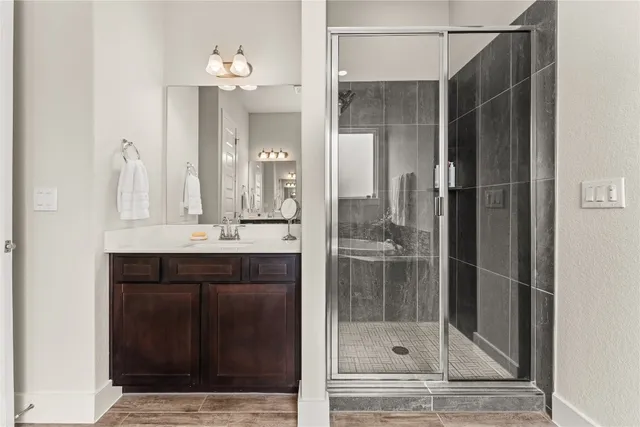 a bathroom with a shower sink and mirror