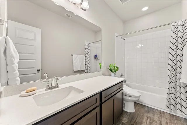 a bathroom with a granite countertop sink toilet a large mirror and shower