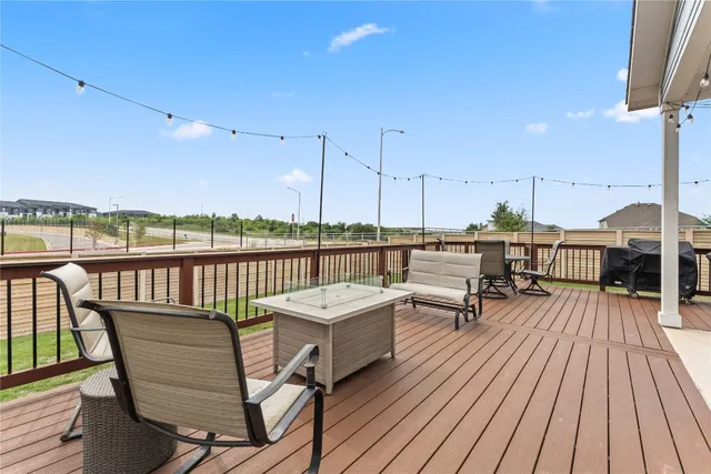 a view of a balcony with chairs wooden floor and fence