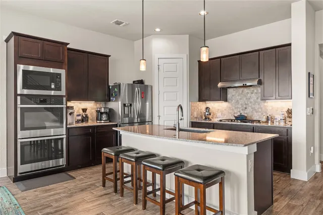 a kitchen with kitchen island a large counter top space appliances and cabinets