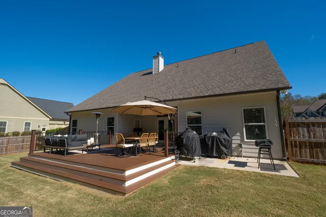 a view of a patio with couches table and chairs under an umbrella