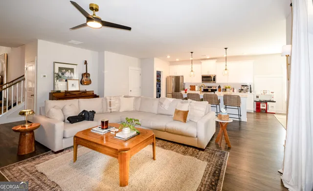 a living room with furniture and a wooden floor
