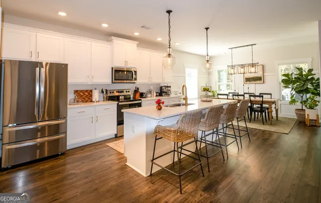 a view of a dining room and livingroom with furniture wooden floor a chandelier