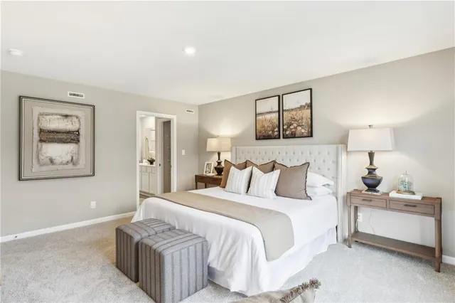 a bedroom with a bed and a lamp on desk