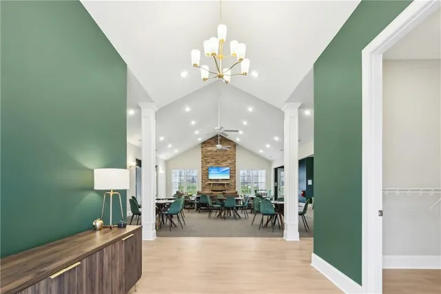 a view of a dining room with furniture a chandelier and kitchen view
