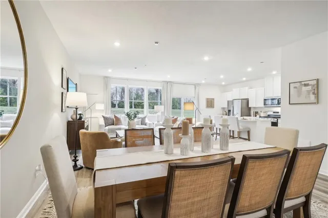 a dining room with stainless steel appliances kitchen island granite countertop a dining table and chairs