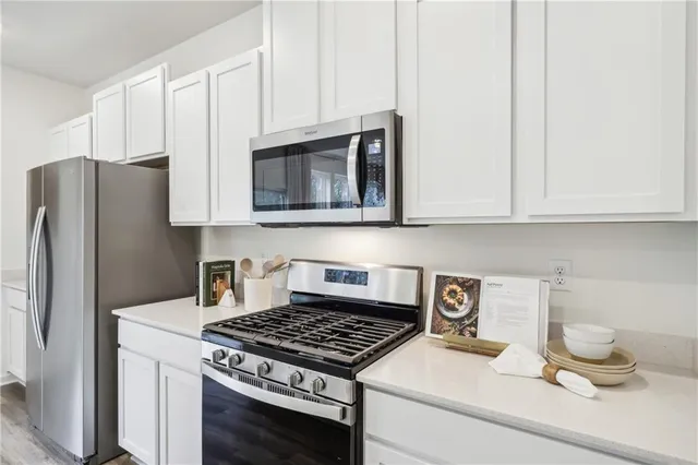 a kitchen with granite countertop a stove and a white cabinet