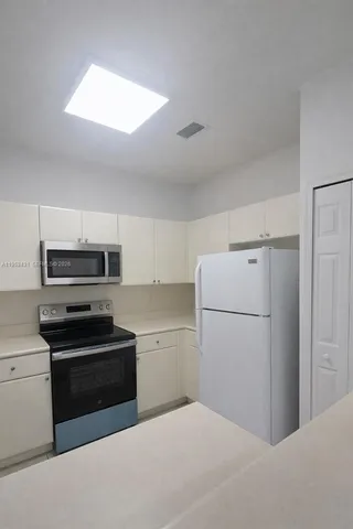 a kitchen with a refrigerator sink and cabinets