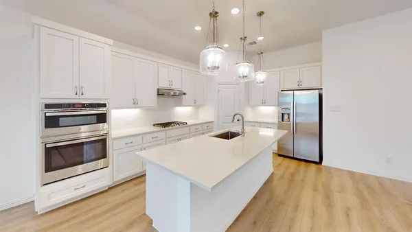 a kitchen with kitchen island a stove a sink and a refrigerator