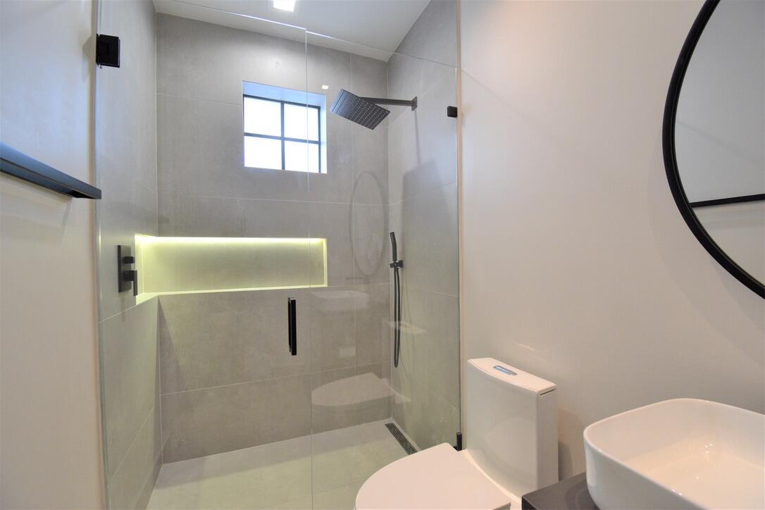 4866 Northwest 16th Avenue Boca Raton, FL 33431 - Photo 32 of 68 a bathroom with a toilet a sink and mirror