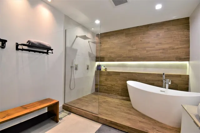 an aerial view of ocean and residential houses with outdoor space