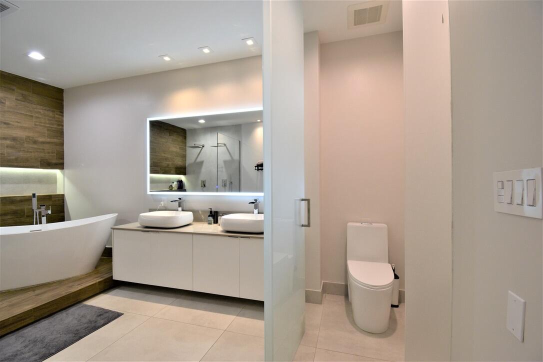 4866 Northwest 16th Avenue Boca Raton, FL 33431 - Photo 45 of 68 a en suite bathroom with a toilet sink and mirror