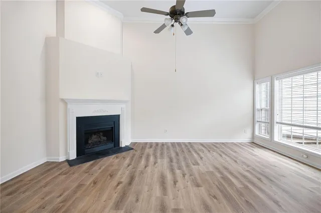 a view of empty room with wooden floor and fireplace