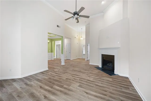 a view of an empty room with a fireplace and a chandelier fan