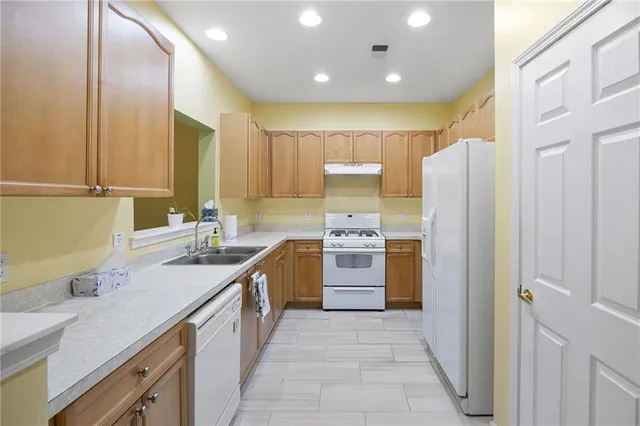 a kitchen with stainless steel appliances granite countertop a sink refrigerator and cabinets