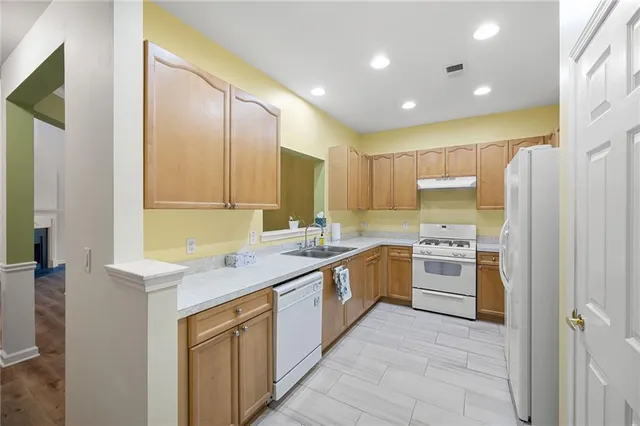 a kitchen with a sink cabinets stainless steel appliances and a window