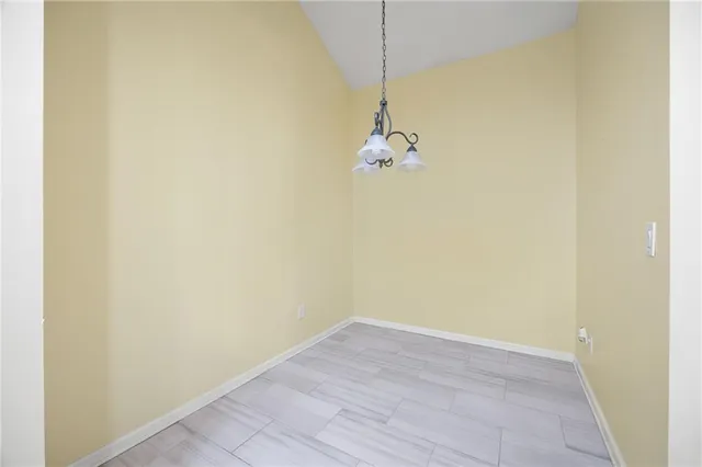 an empty room with a chandelier fan